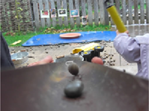 Ready, steady, go! Stones down a drainpipe into a silver bucket. Language and great fun outdoors